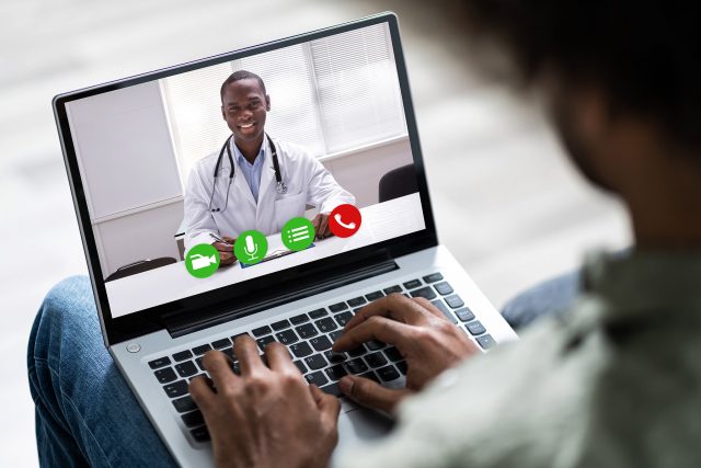 photo of man on video conference with doctor